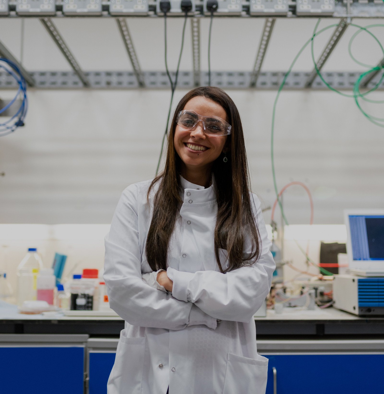 Woman standing in a science lab, smiling and facing the camera